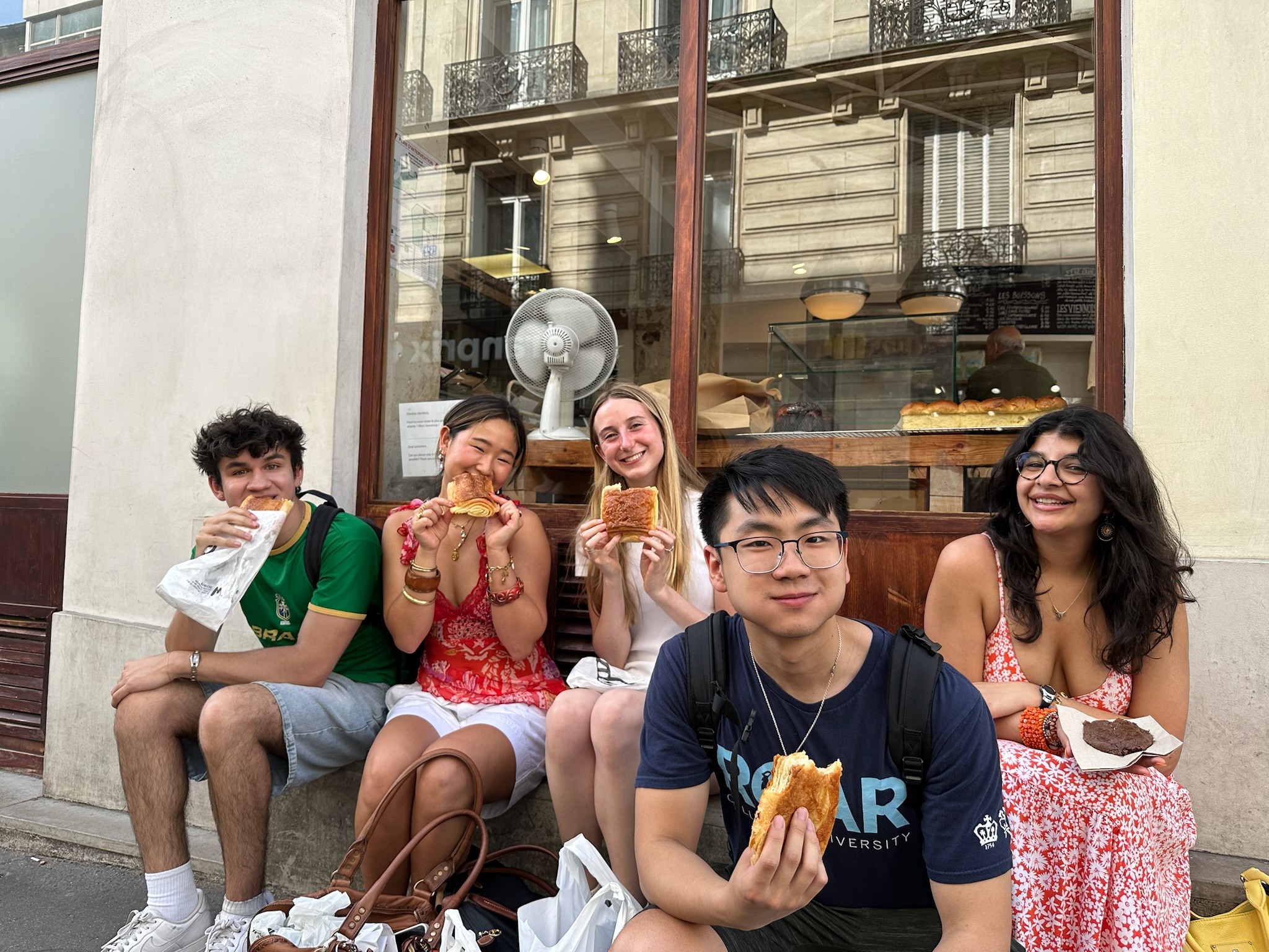 John sitting with friends outside of a patisserie in Paris