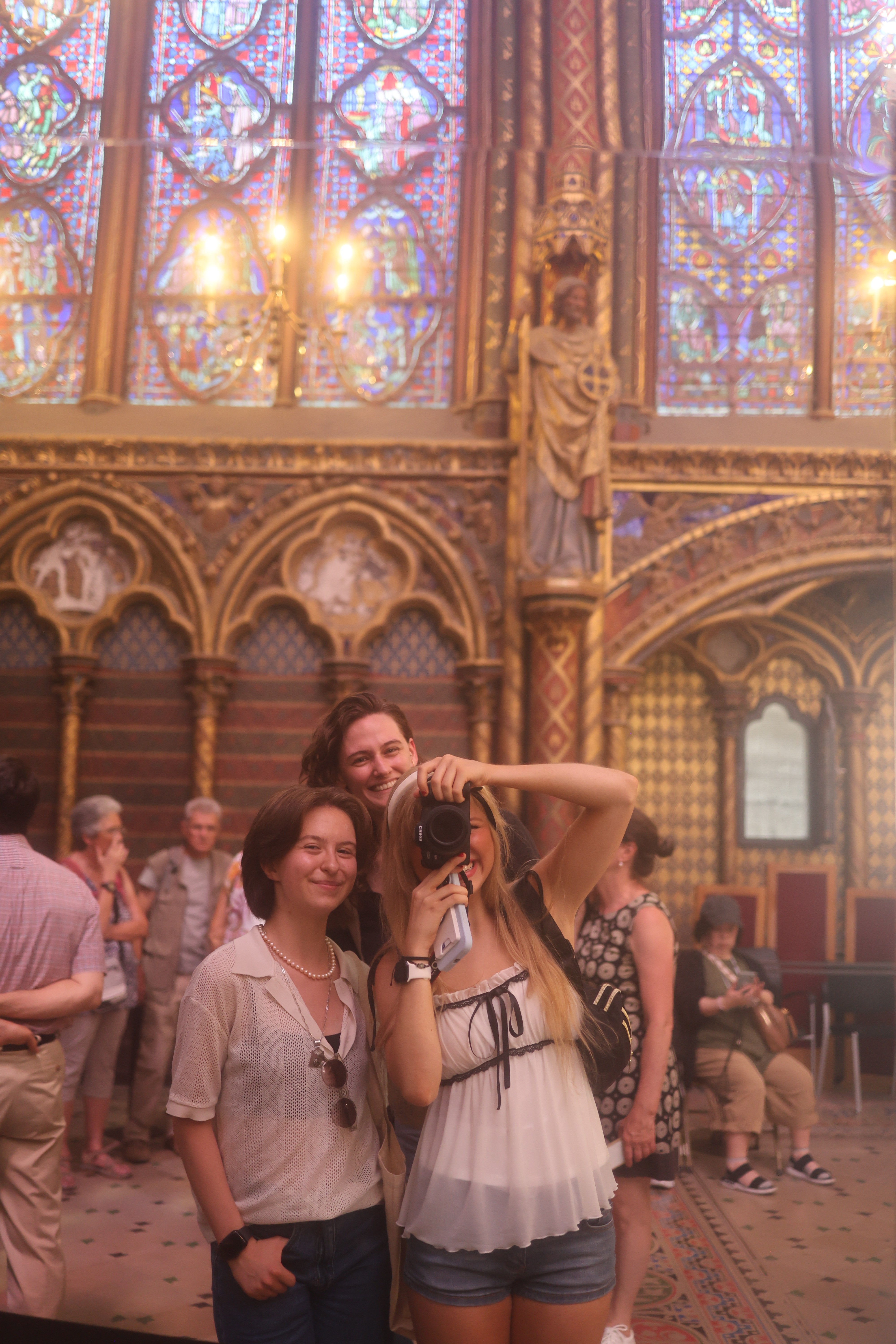 Rose standing with friends in a church taking a photo in a mirror