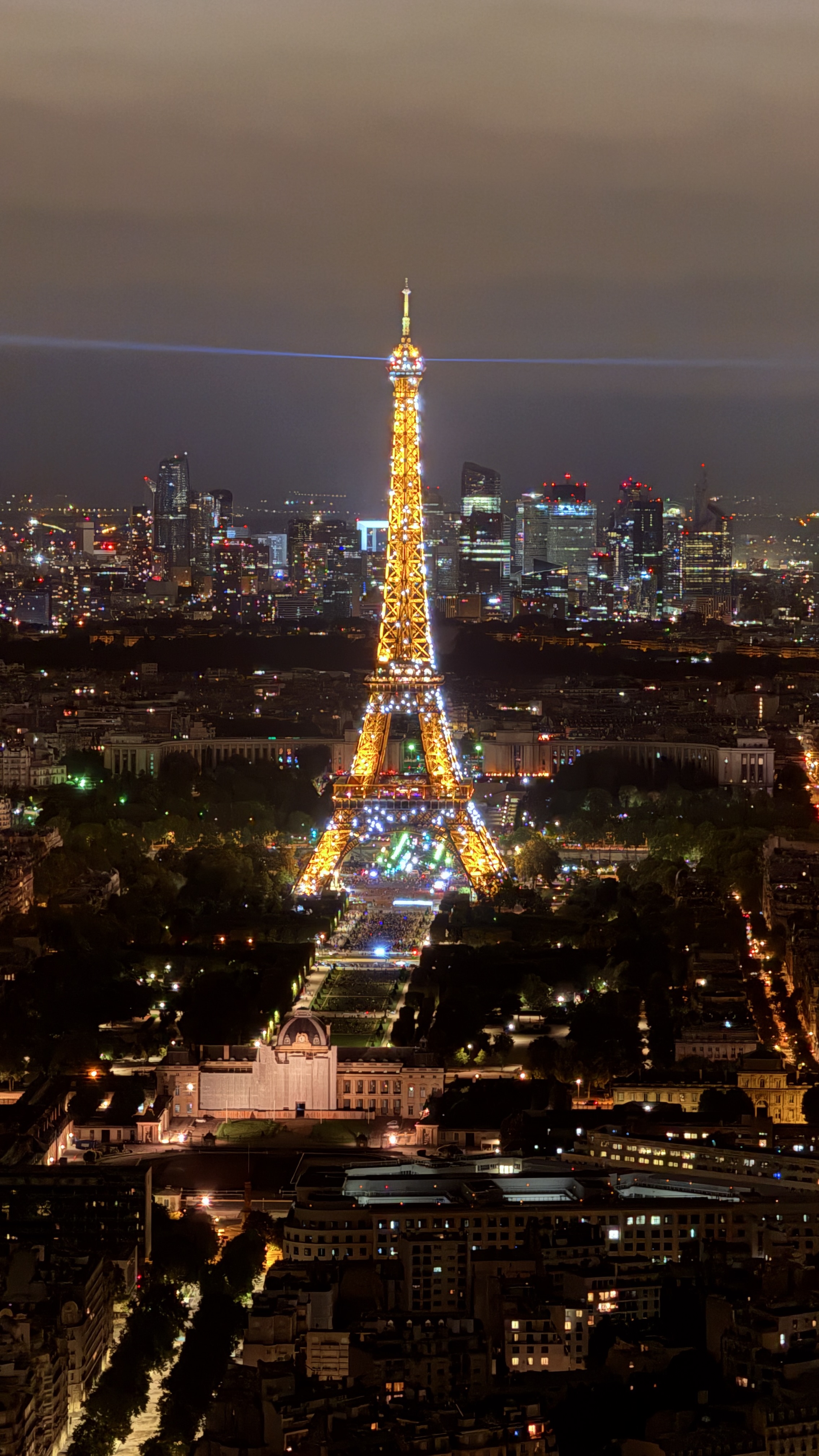 The Effiel Tower at night lit up by yellow and colorful lights