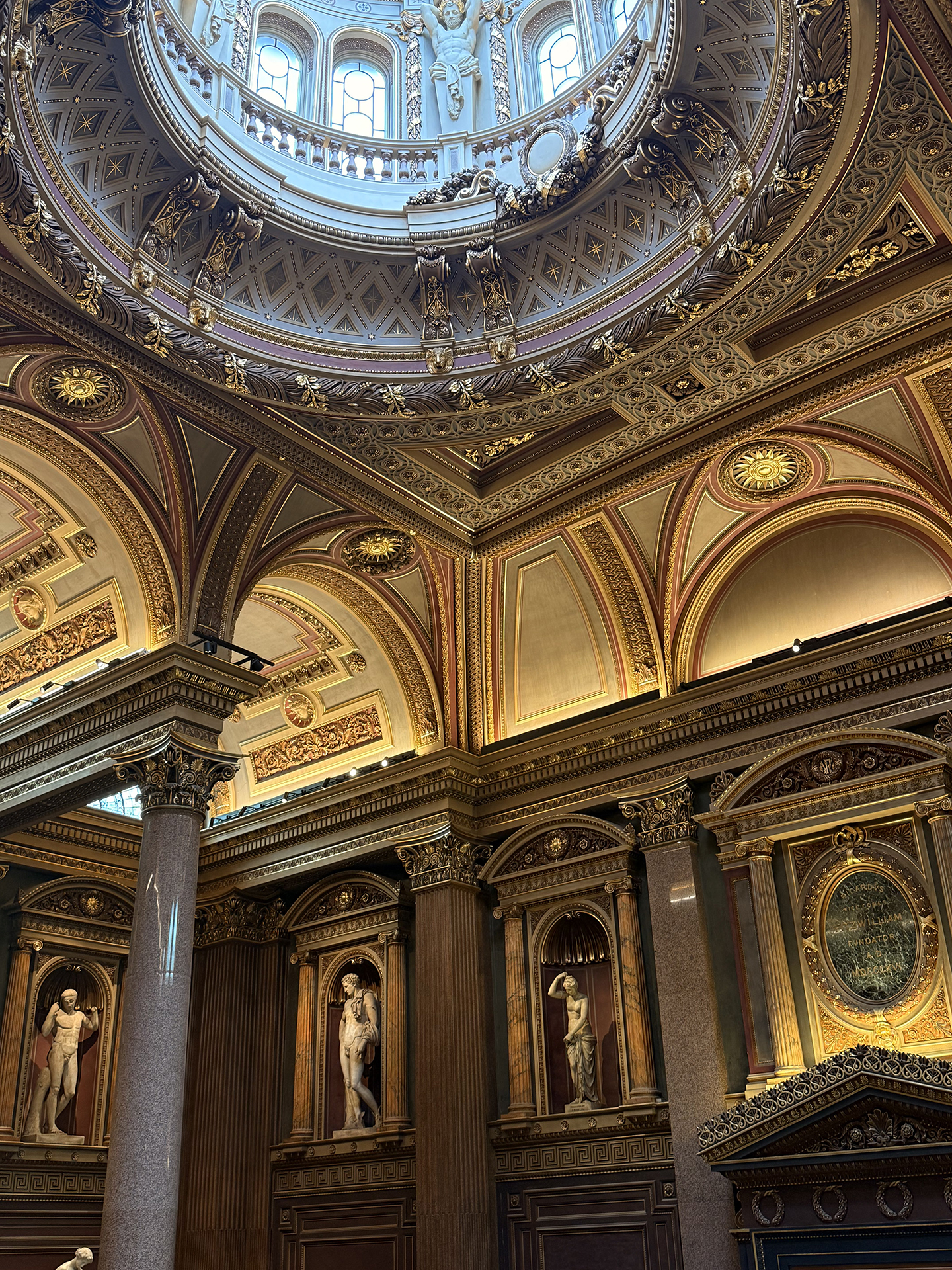 Inside the high arched, dark wood linned, building at Cambridge