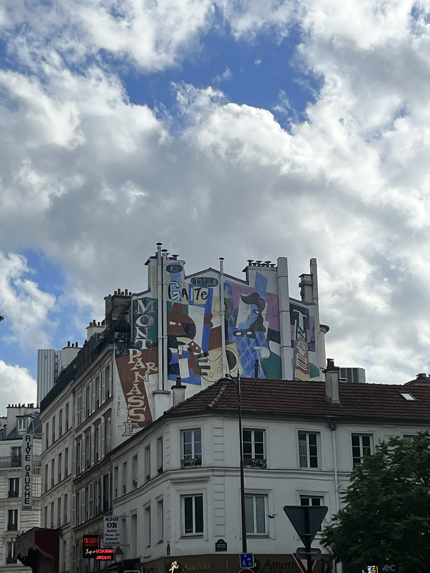 A side of a building with blue and purple graffiti in Paris