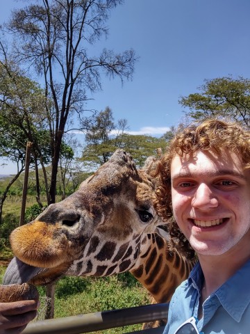 Harrison meeting a giraffe during their time in Nairobi