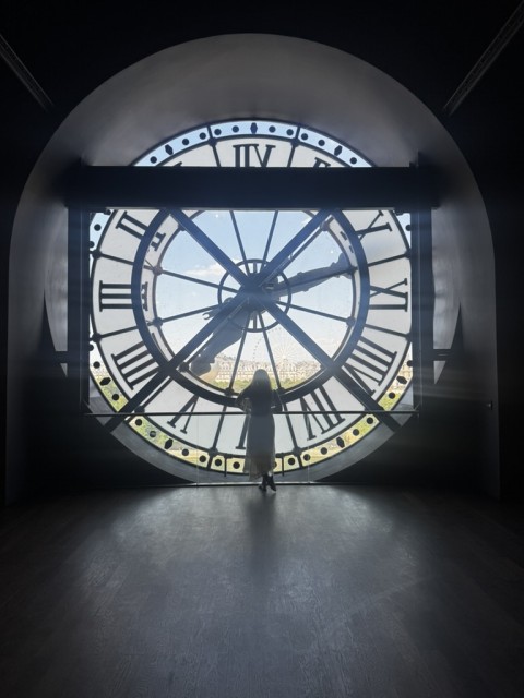 Brooklynne standing inside the Effiel Tower looking out of the clock tower
