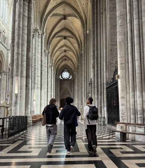 Students walking down a gothic hallway in Paris