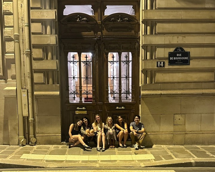 Manuela sitting with friends outside of a building in Paris