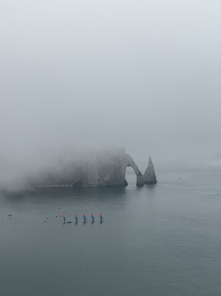 Famous white chalk cliffs and natural arches covered in a mist where the land meets the sea.