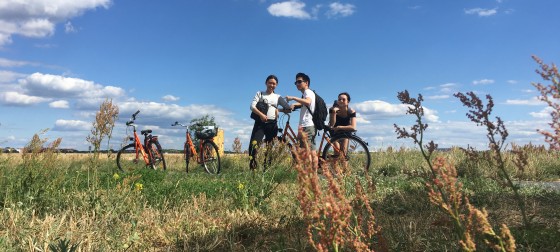 Bikes and students in a field with clouds