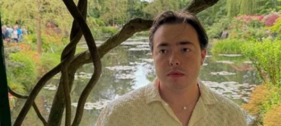Crawford standing and looking off to the distance in a park