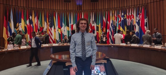 Harrison visiting the UN with the world flags behind them