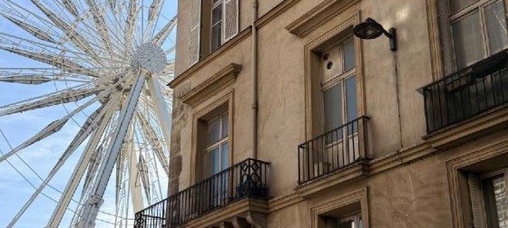 A ferris wheel behind a stone building