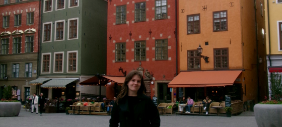 Shaylee Gill standing in front of brightly colored buildings in Stockholm, Sweden
