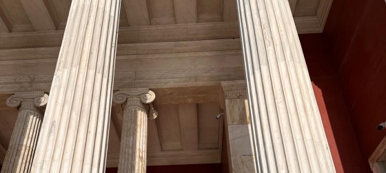Olivia Franklin and another student standing next to marble columns in Athens.