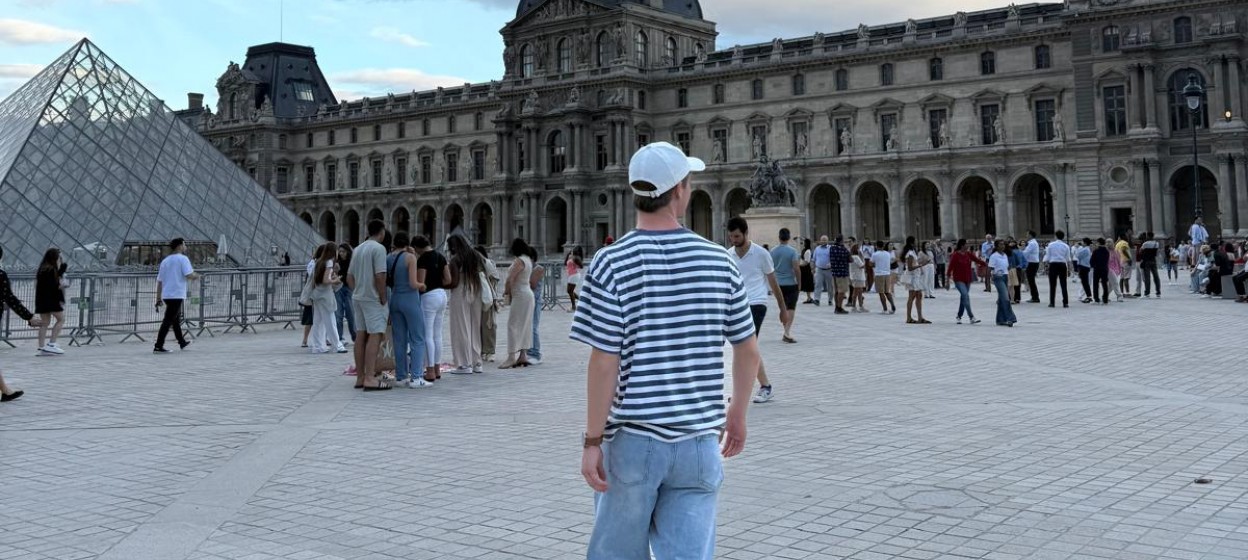 Wesley standing near the Louvre looking away from the camera