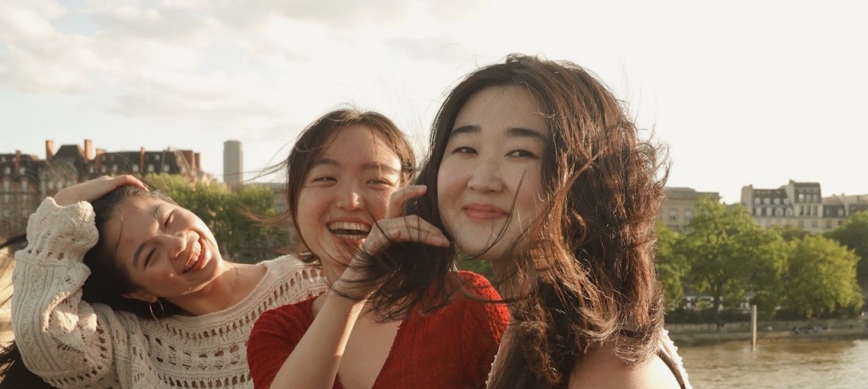 Khanh Doan sitting with friends and smiling at the camera