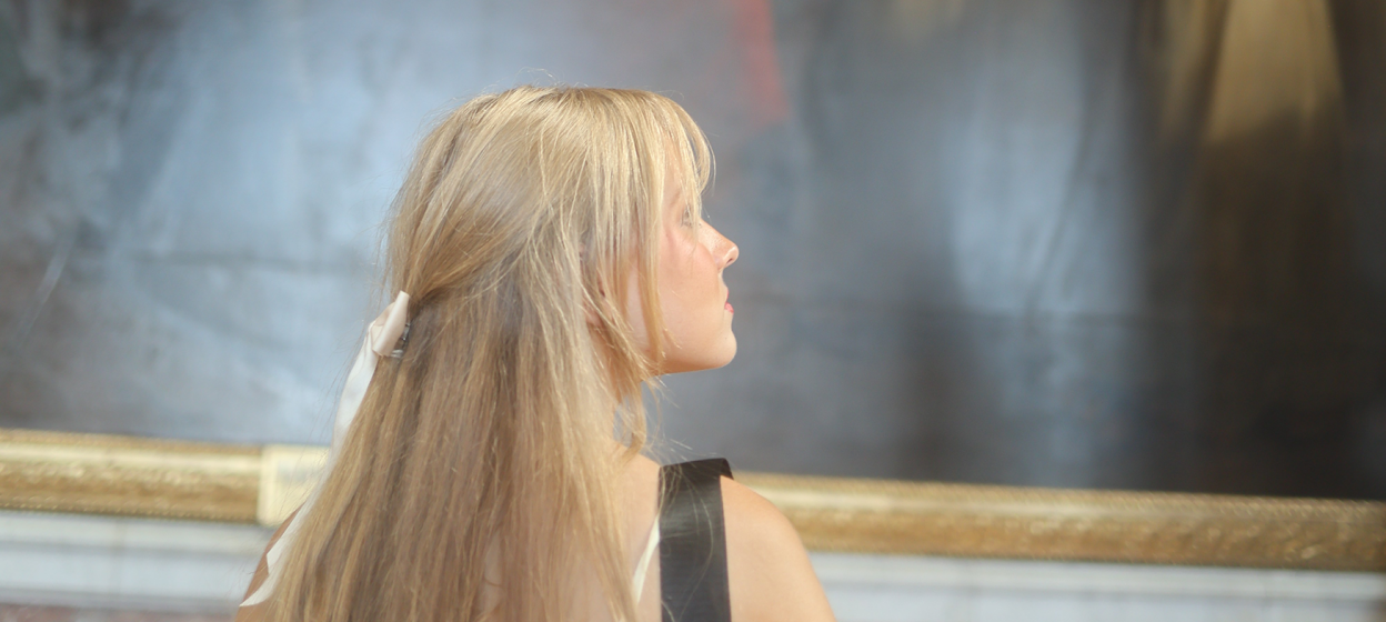 Rose Tuttle standing in front of a painting in a musuem
