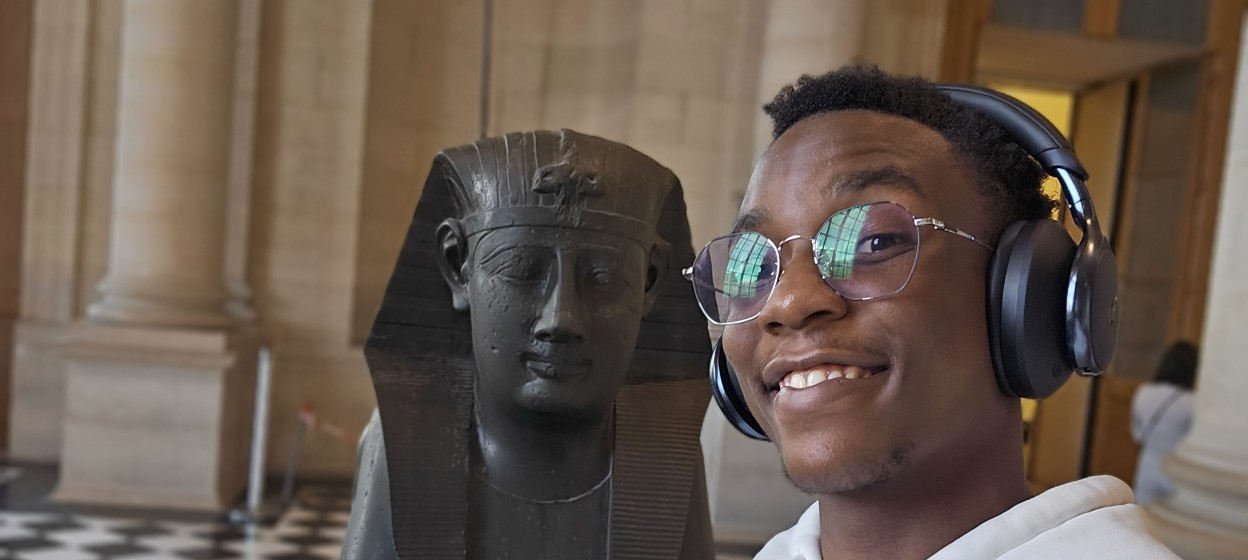 Melnick standing in from of an Eqyptian statue in a museum