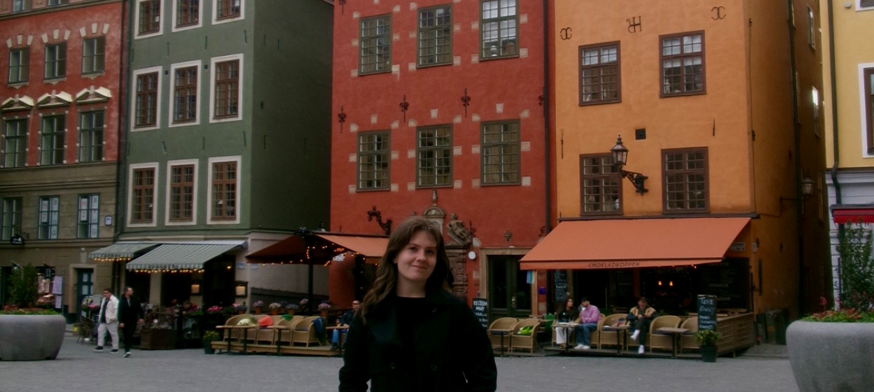 Shaylee Gill standing in front of brightly colored buildings in Stockholm, Sweden