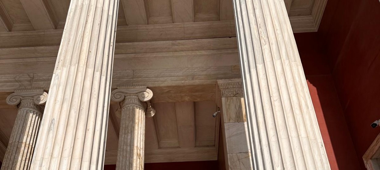 Olivia Franklin and another student standing next to marble columns in Athens.