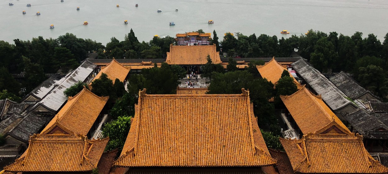 A birds eye view of the Summer Palace in Beijing, China. The building has an orange roof and looks out to the ocean