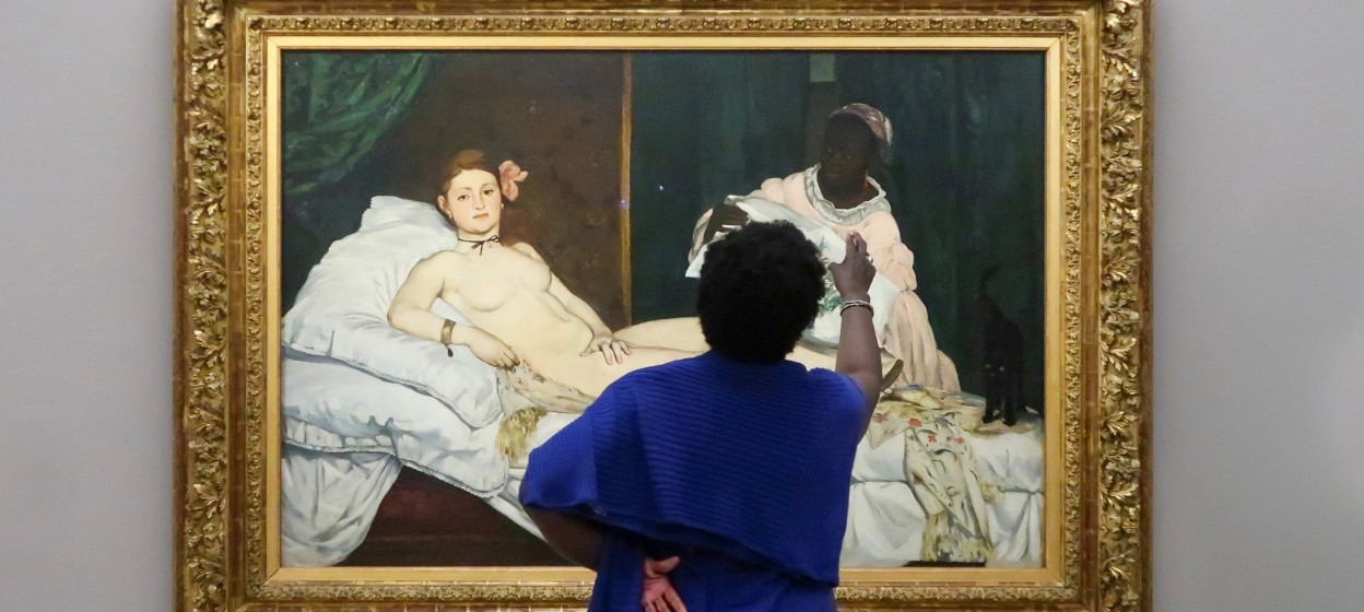 A woman looking and pointing at a painting