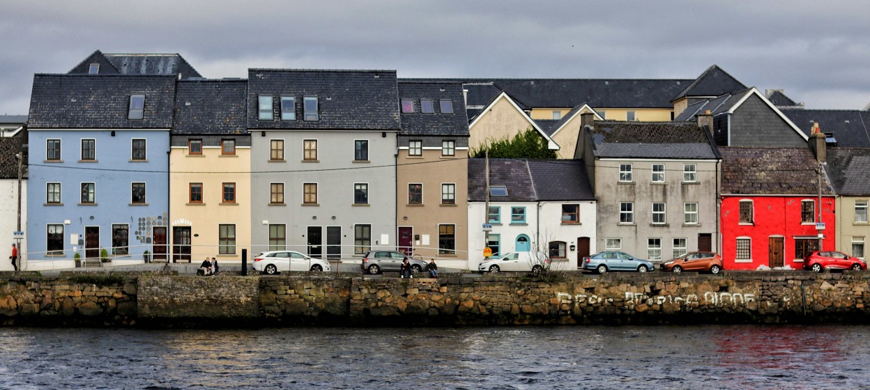A row of houses in Galway next to a body of water