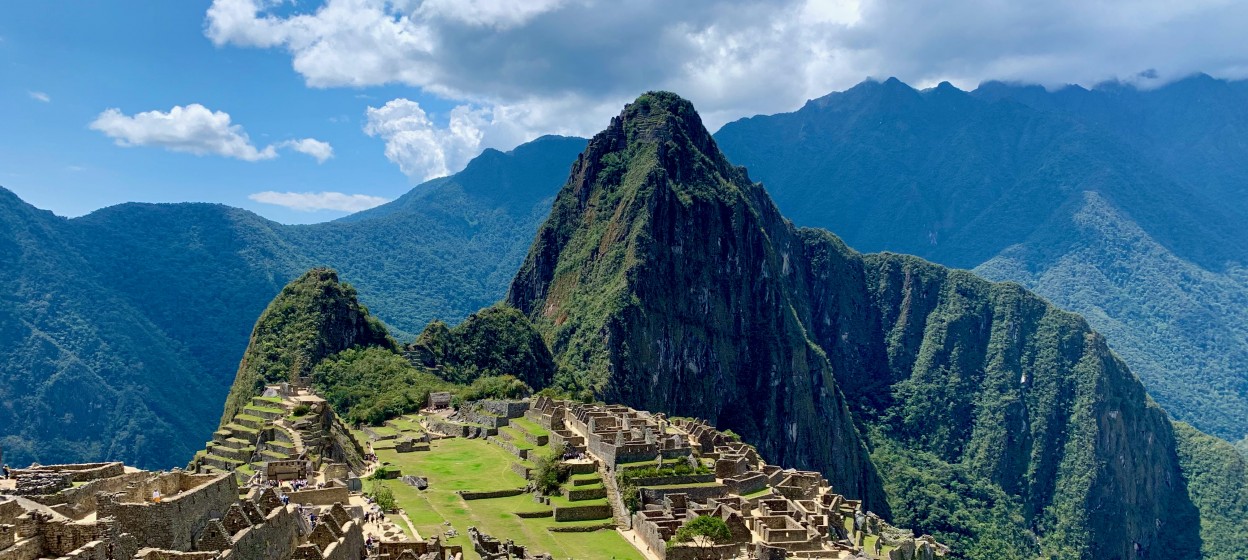 Machu Picchu, Peru surrounded by green mountains and ancient stone architecture. 