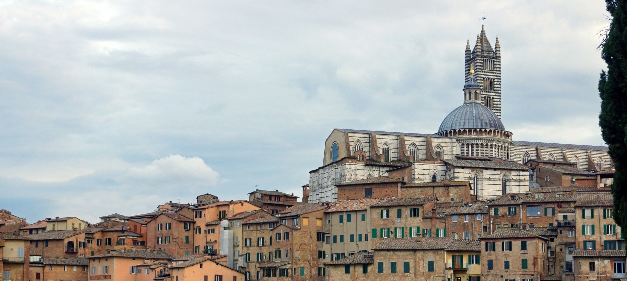Skyline of church overlooking old city of Siena, Tuscany in Italy on a cloudy day