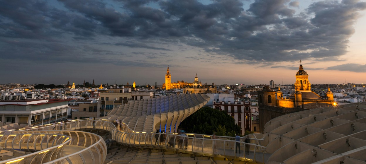 City buildings of Seville under gray clouds during the night