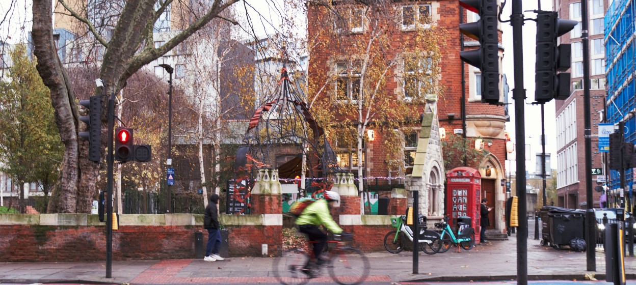 A man riding a bike down a street in East London