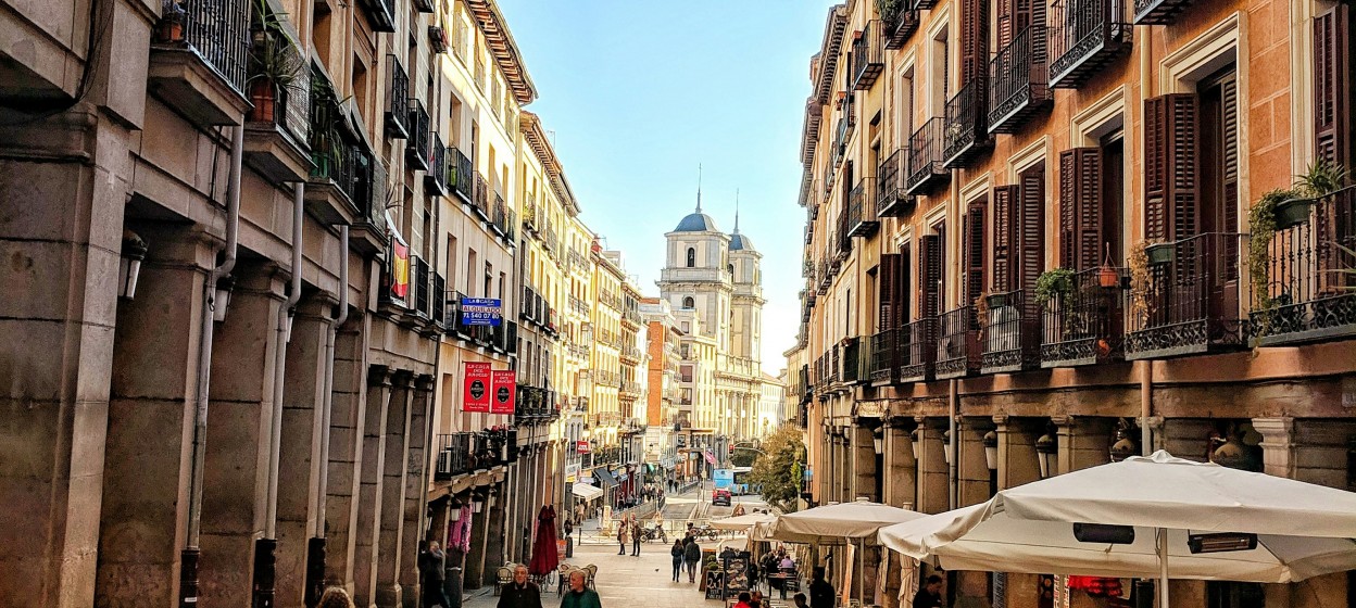 People walking the narrow streets of Madrid during the day
