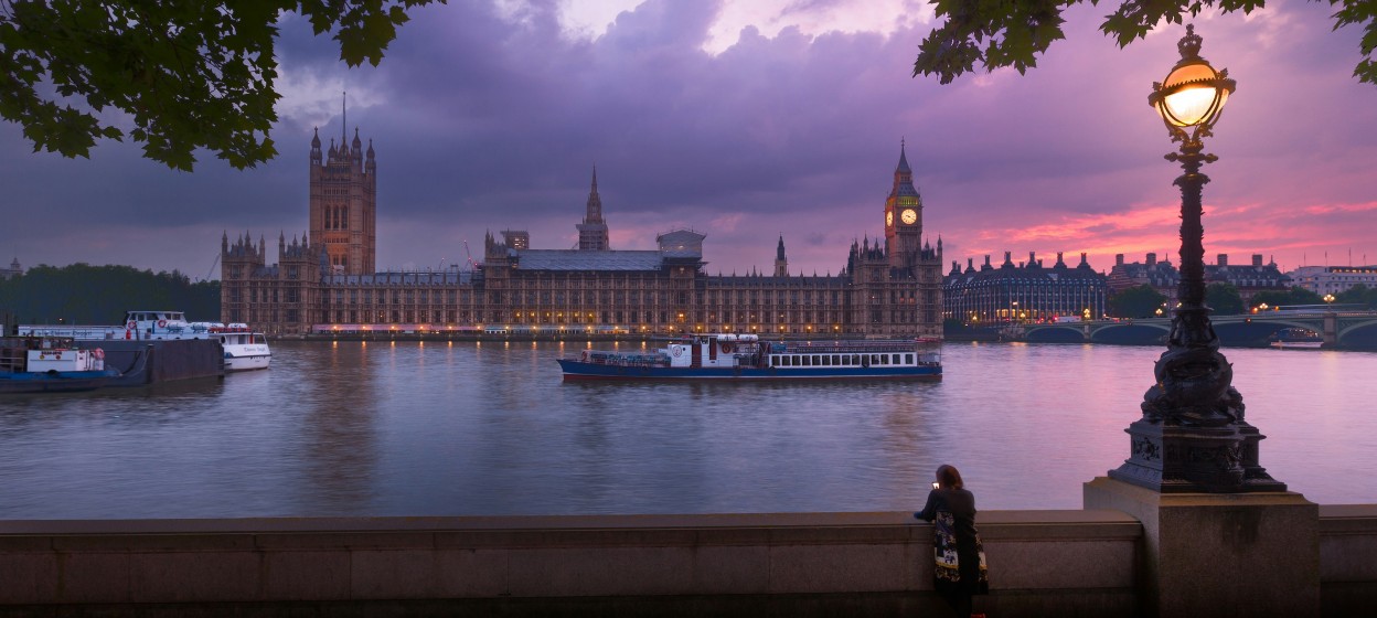 Person standing and looking out at the River Thames