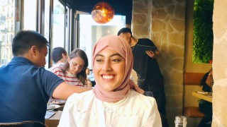 Hafsa Mohammed Abdul Samad sitting in a resturant smiling to the camera