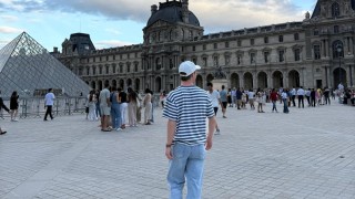 Wesley standing near the Louvre looking away from the camera