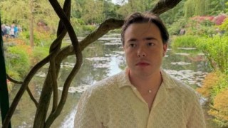 Crawford standing and looking off to the distance in a park