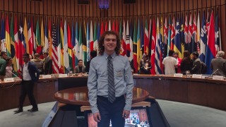 Harrison visiting the UN with the world flags behind them