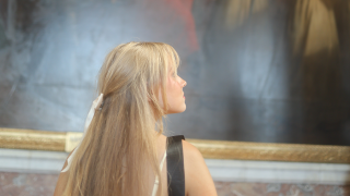 Rose Tuttle standing in front of a painting in a musuem