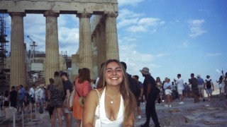 Regina standing in front of the acropolis in Athens, Greece