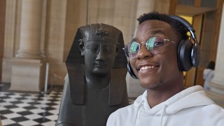 Melnick standing in from of an Eqyptian statue in a museum