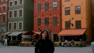 Shaylee Gill standing in front of brightly colored buildings in Stockholm, Sweden