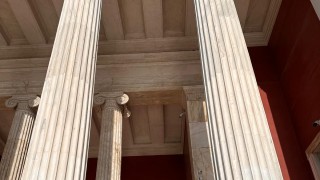 Olivia Franklin and another student standing next to marble columns in Athens.