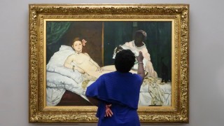 A woman looking and pointing at a painting
