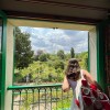 A student looking out of a window that shows a green garden