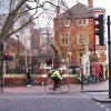 A man riding a bike down a street in East London