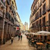 People walking the narrow streets of Madrid during the day
