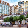 People walking on a street near colorful buildings in Lisbon during the daytime